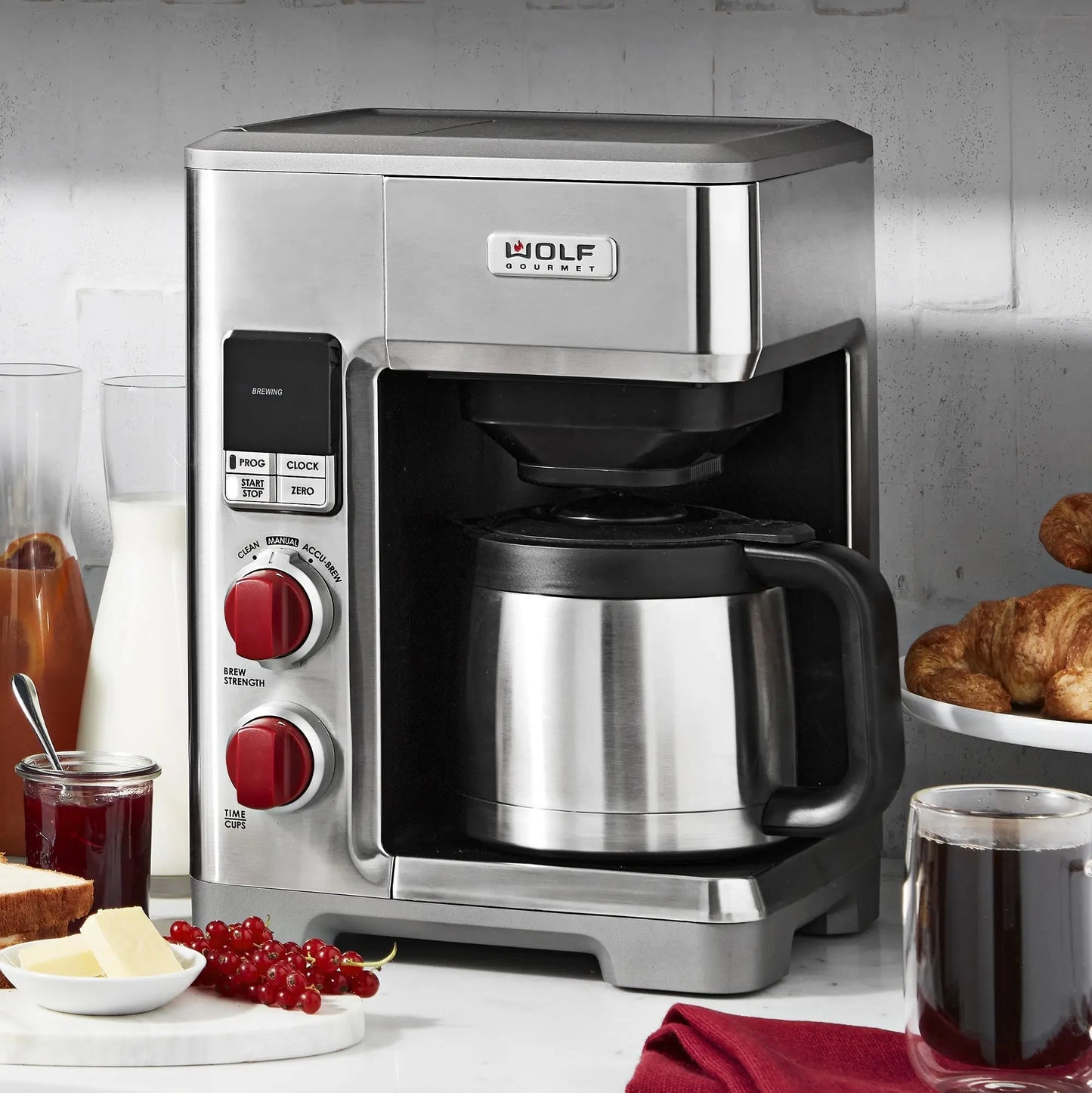 Wolf Gourmet automatic drip coffee maker brewing a fresh 10-cup pot with glass carafe and digital controls.